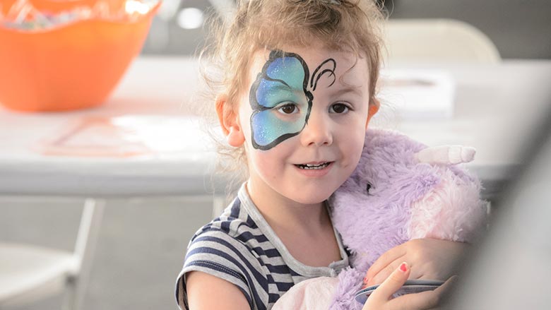 Young girl with a butterfly wing painted on her face