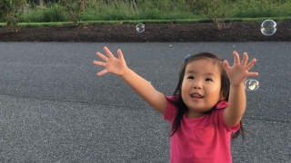 Avery playing with bubbles outside