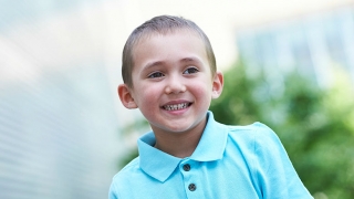 Young boy smiling outside