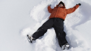Young child making a snow angel