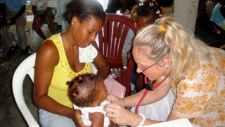 Lara treating a baby, global health