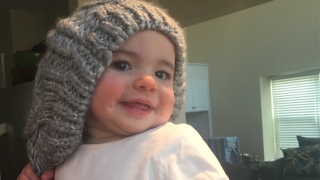 Lilly smiling wearing a grey beany hat