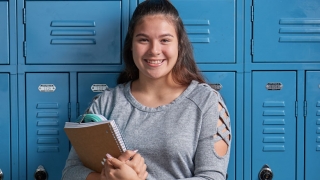 Smiling teenage in front of lockers