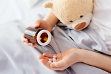 Patient's hand holding pills and bottle Patient's hand holding pills and bottle