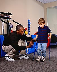 Picture of young boy, with canes, during a physical therapy session