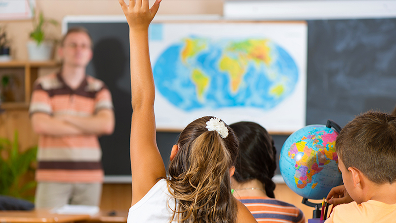 Girl raising hand in school classroom