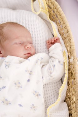 Baby sleeping on his back in a bassinet