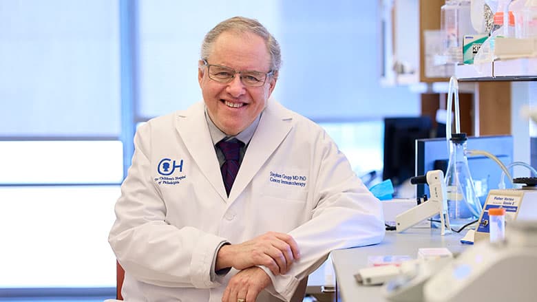 Dr. Grupp wearing a white coat in a lab