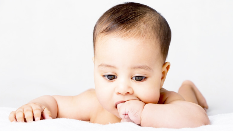 Teething baby chewing on hand