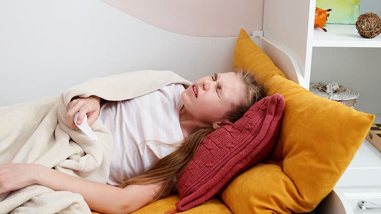 Girl laying in bed with stomach pains Girl laying in bed with stomach pains