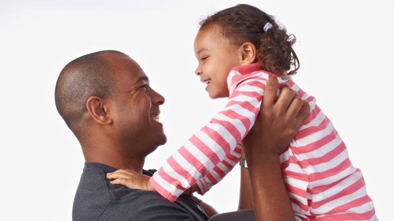 father holding up daughter