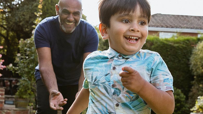 Chasing grandson in the garden during outdoors playtime.