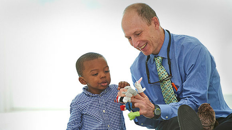 Doctor with patient playing with finger puppets