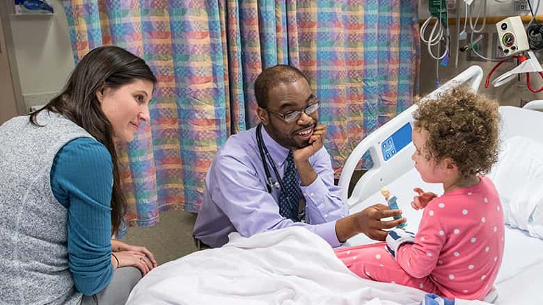 Doctors with patient in exam room