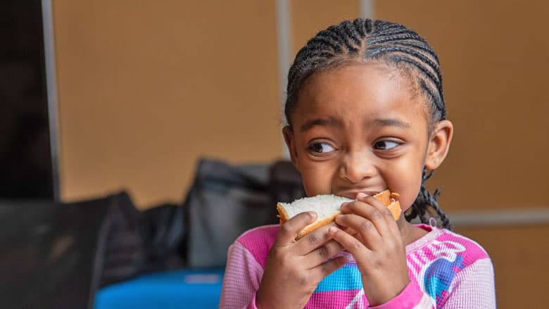 Young girl eating a sandwich