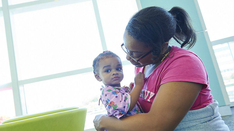 Mother holding young daughter