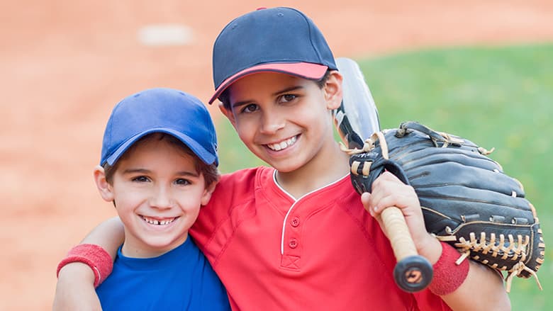 Two young boys in their baseball uniforms
