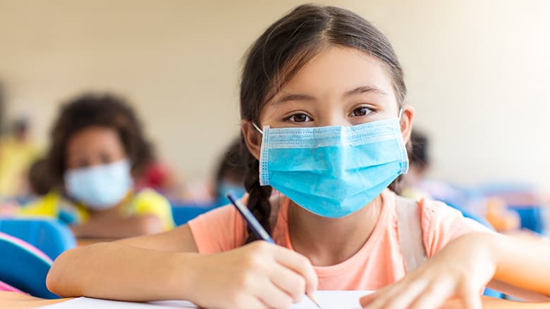 Children in classroom wearing protective masks