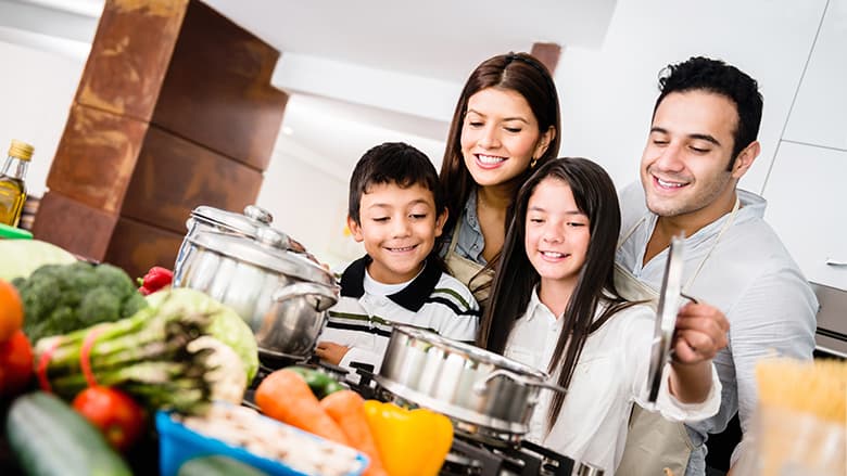 Family in kitchen watching over stove