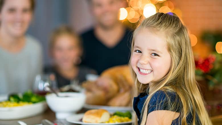 Young girl smiling at Thanksgiving table