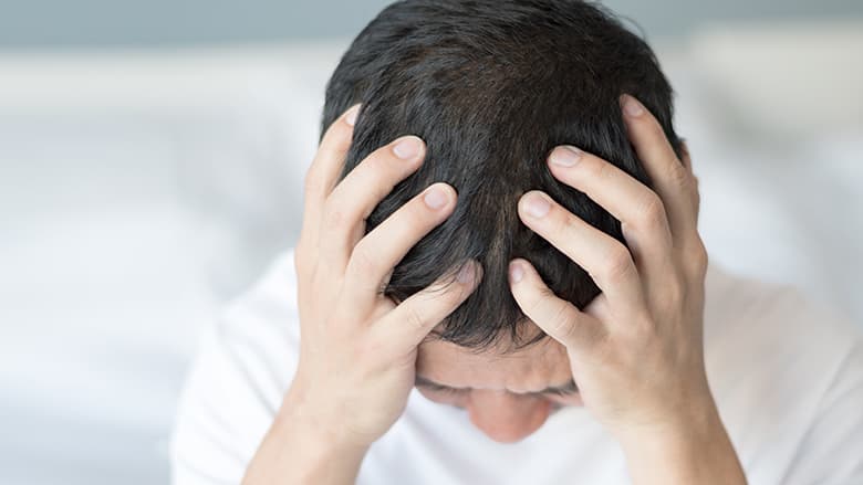 Older child holding his head in his hands