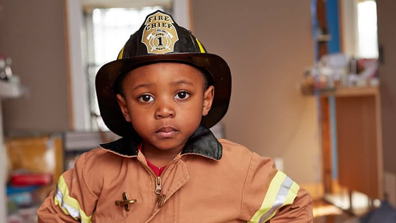 Young boy wearing fire fighter helmet