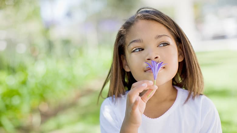 Young girl smelling a flower