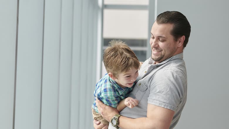 Father holding rowdy child