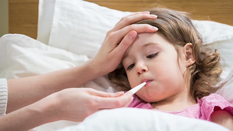 Young girl getting temperature taken