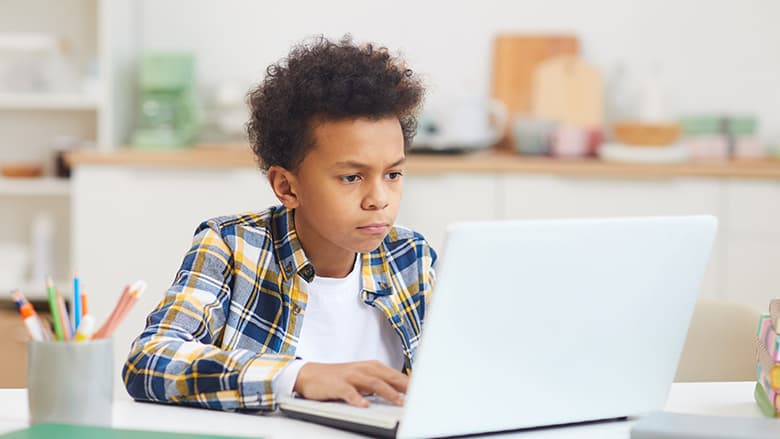 Young boy looking at laptop screen Young boy looking at laptop screen