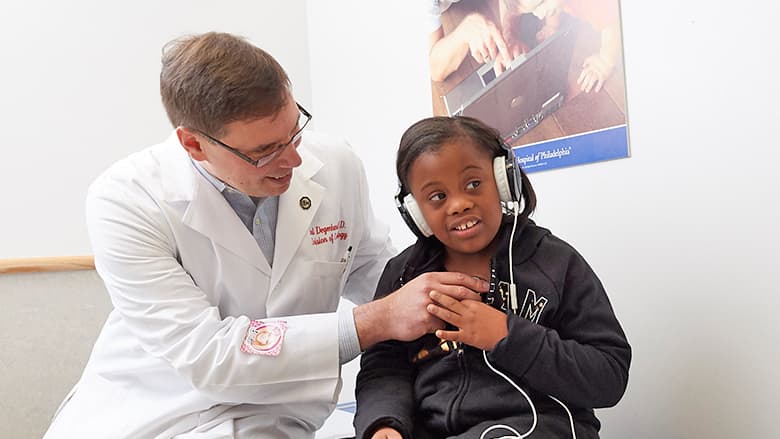 Doctor giving hearing exam to female patient