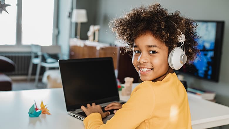 Young girl smiling and using her laptop Young girl smiling and using her laptop