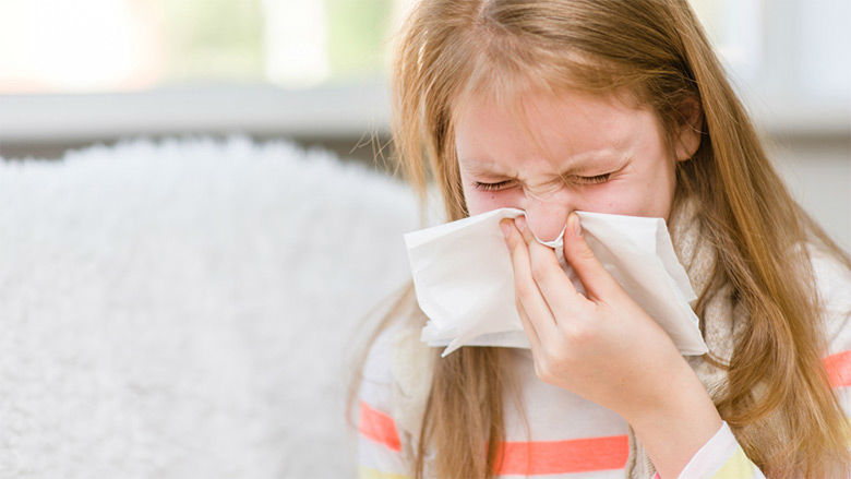 Young girl sneezing