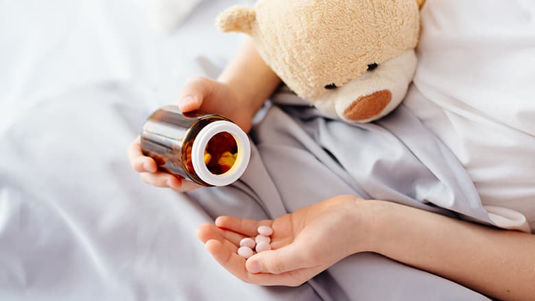 Patient's hand holding pills and bottle