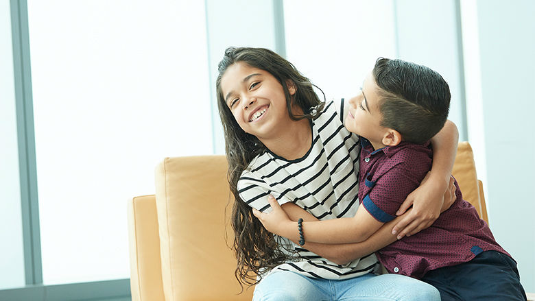 Sister and brother hugging