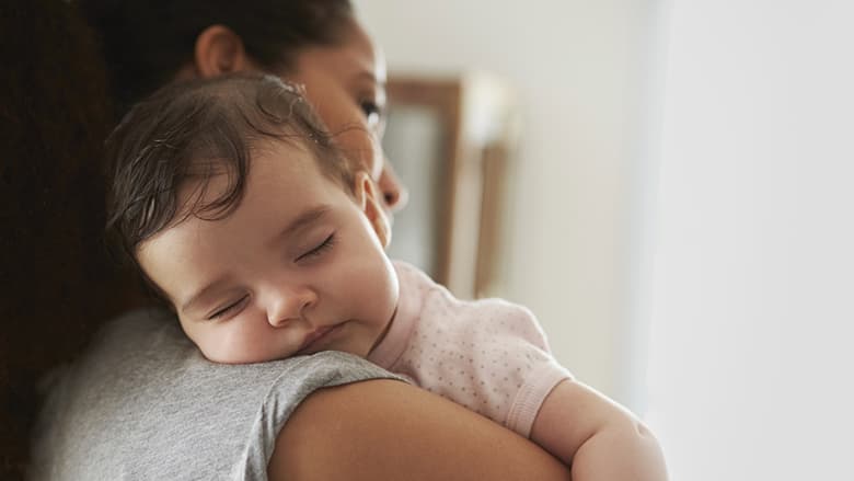 Mother holding sleeping infant