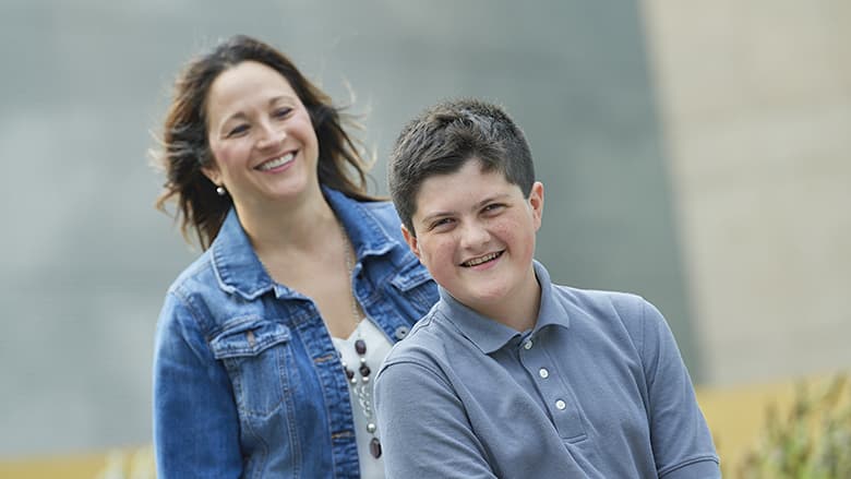 Mother standing behind son