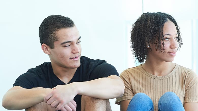 Teenaged boy and girl sitting together