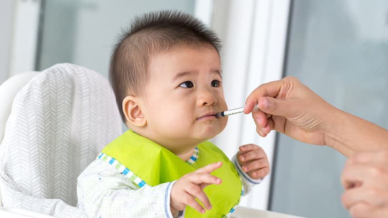 Young baby taking oral injection medicine