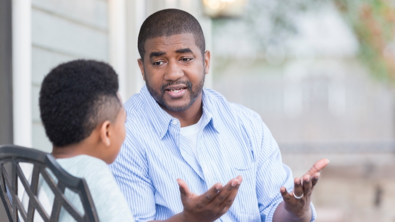 Parent and child sitting on bench talking