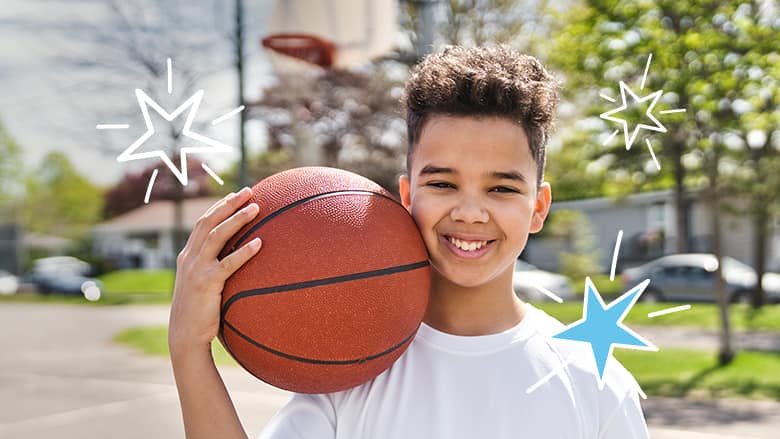 Boy smiling holding a basketball