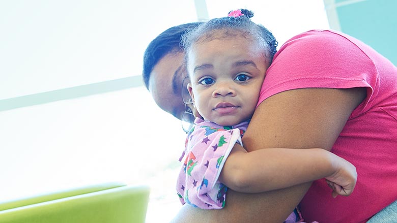 Mom hugging toddler daughter