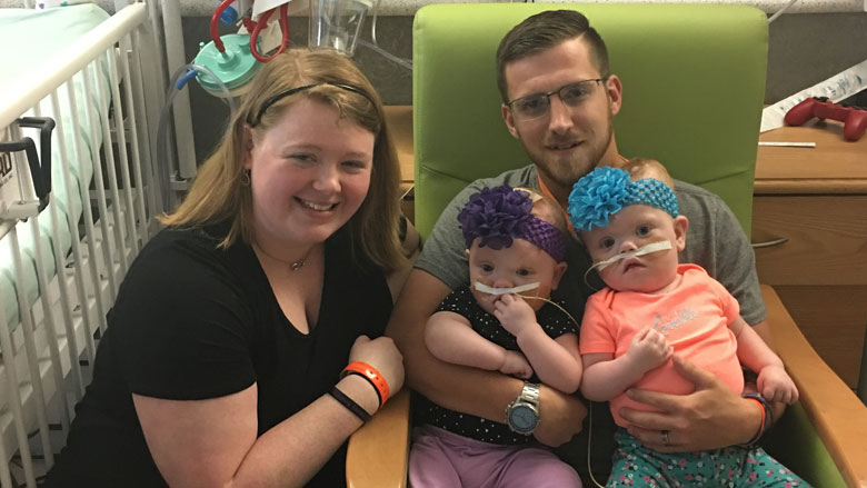 Mom and Dad holding the twins after separation