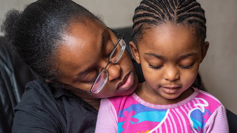 Mother holding daughter close