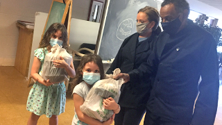 Chef with two girls holding food donations