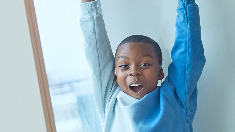 Young boy with arms up in celebration