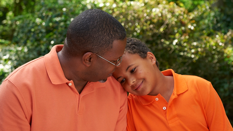 son leaning head on fathers shoulder