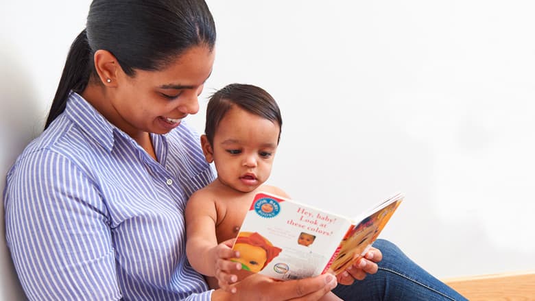 Mom reading book to toddler daughter
