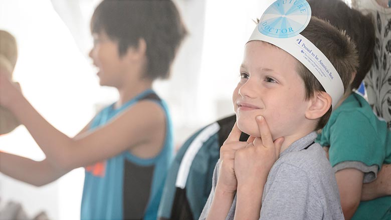 Young boy wearing a paper doctor's head mirror