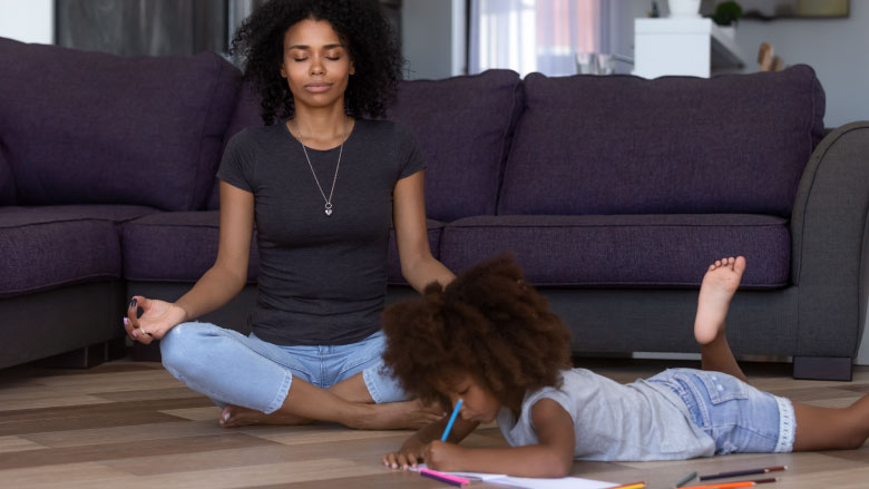 mom meditating while daughter is coloring